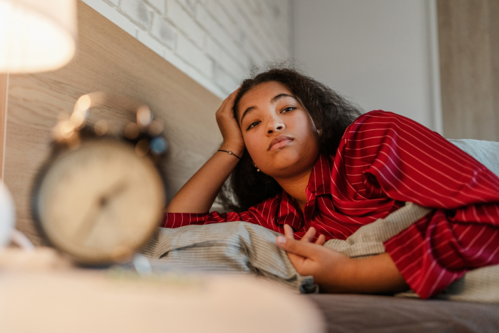 woman struggling to go to sleep laying in bed propped up on her hand wondering if can gabapentin help you sleep