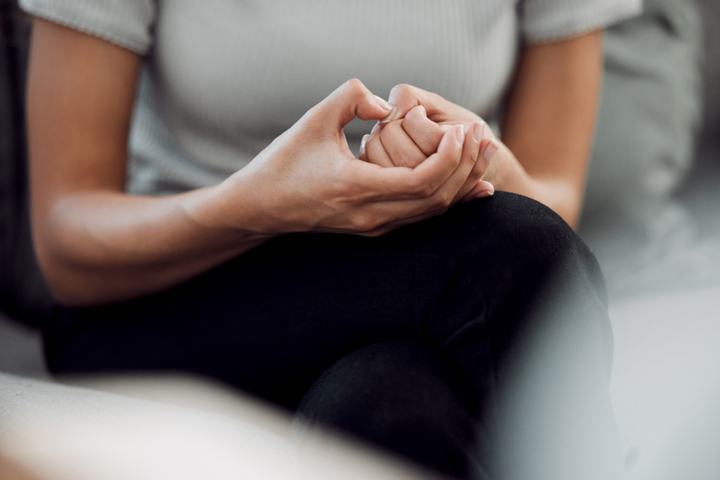 woman sitting on the couch picking at her hands speaking with her psychiatrist about ADHD medication for Adults with Anxiety