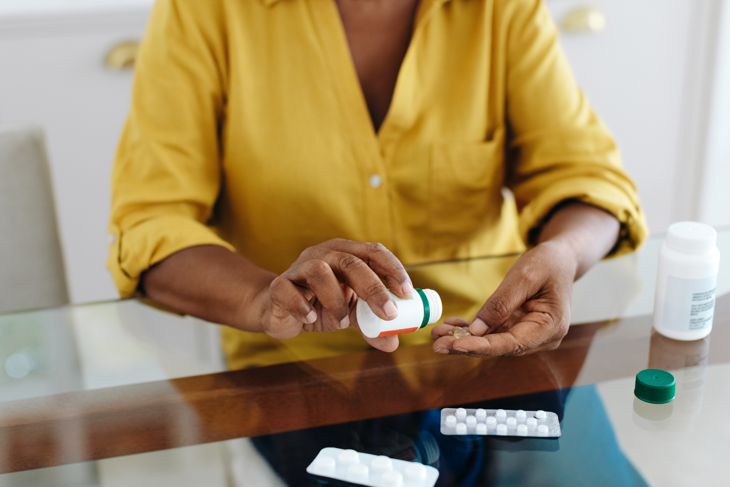 woman sitting at a table taking her wellbutrin medication