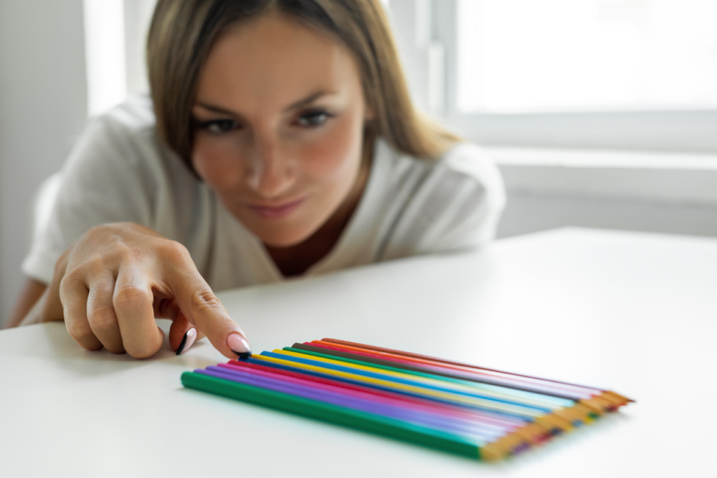 woman with ocd struggling to organize pencils wondering can trauma cause OCD?